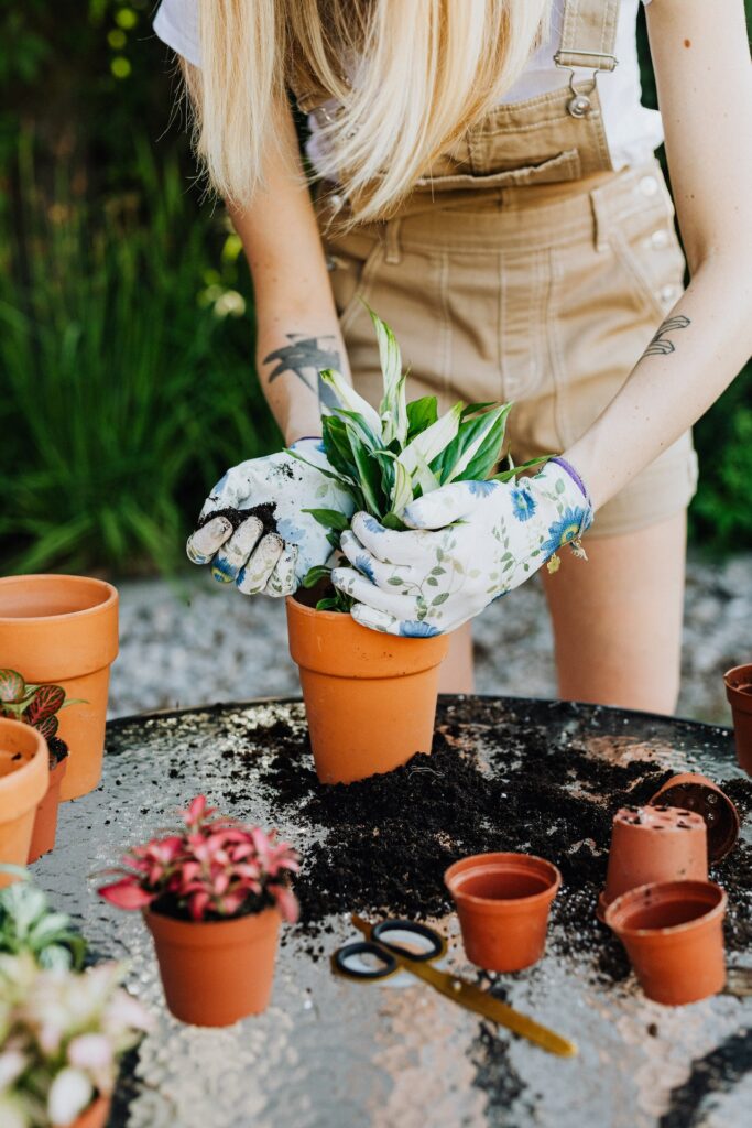Woman in overalls and gloves gardening