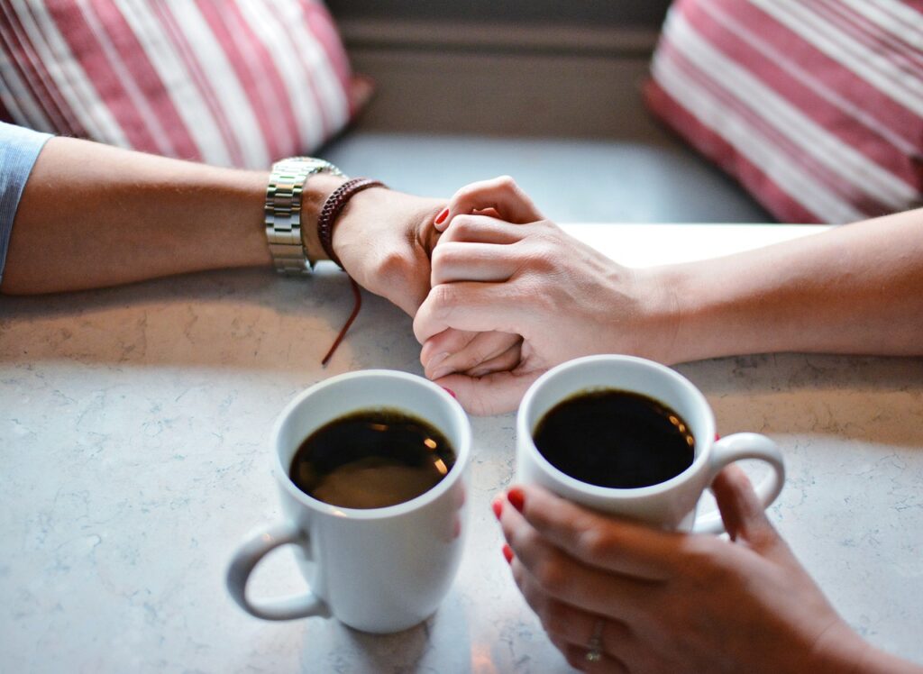 Couple holding hands with coffee